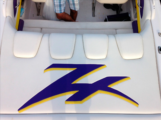 Upholstery on the back end of a speed boat that shows a yellow and purple logo.